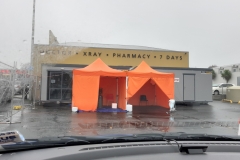 Orangenes Testzelt und rechts daneben der "Arztcontainer"